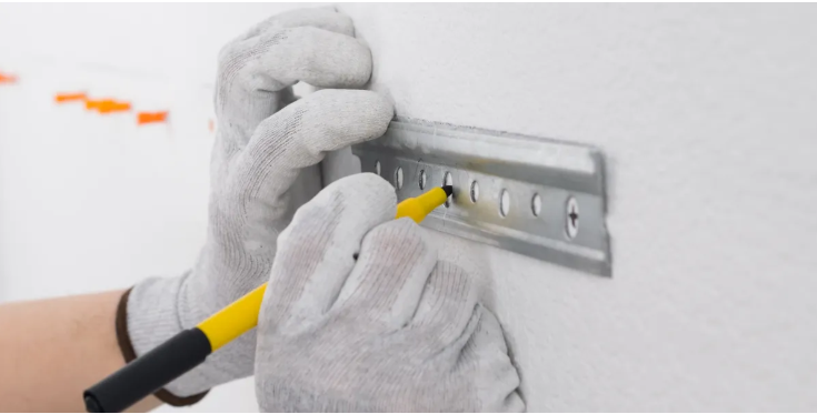 Installer marking drill points for a wall-mounted bracket