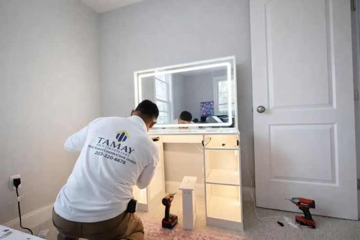 Tamay Enterprises technician assembling a vanity with LED mirror in a client home