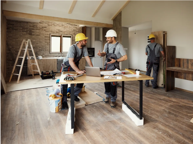 Construction team reviewing renovation plans at a job site