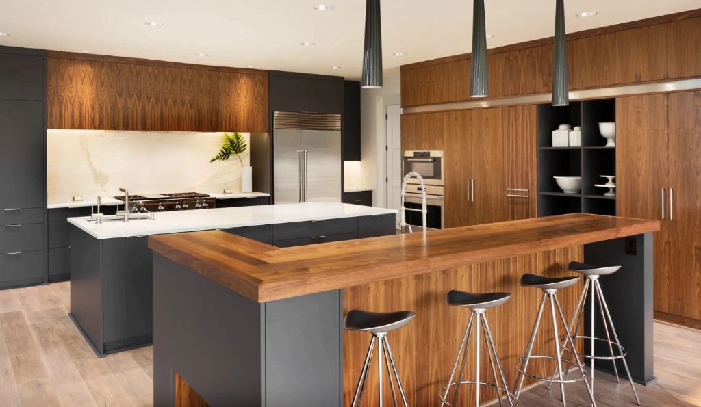 Custom kitchen island with white quartz counters, charcoal cabinetry, walnut accents, and stainless appliances
